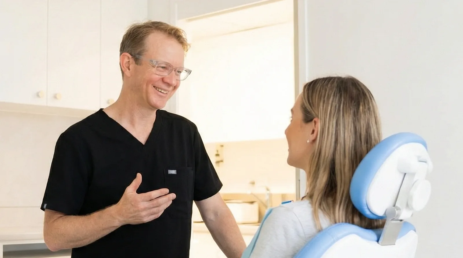 Dr Andrew smiling as he talks through the options with a relaxed patient seated in the dental chair at Grange Road Dental in Ipswich